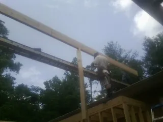 Carpenter setting a ridge beam over a new addition frame — Ice Dam Removal by Roofing Brothers in Ringwood